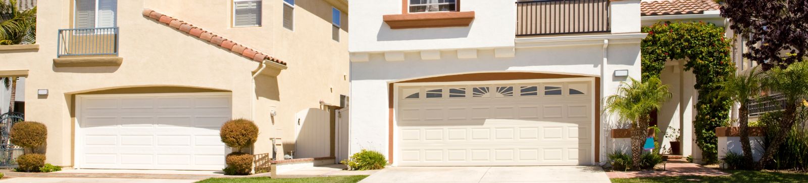 Two modern homes in Fern Park, FL, each featuring stylish, custom-designed garage doors and well-maintained exteriors under a clear blue sky.