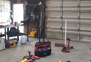 Wide shot of a Fern Park garage showing a new, heavy-duty garage door, technician’s tools, and a well-organized workspace.