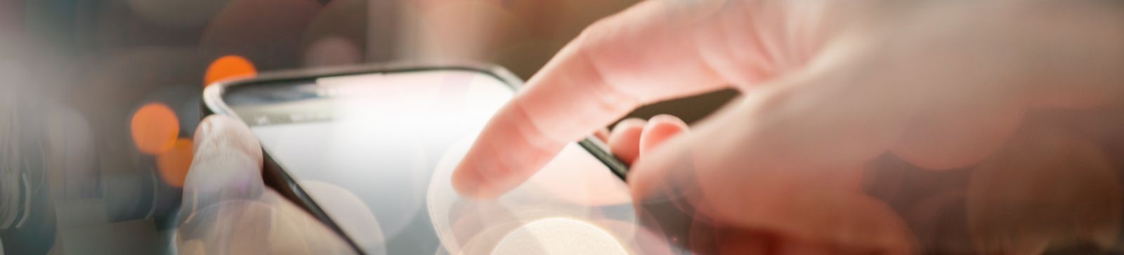 Close-up of a hand using a smartphone app to control a garage door, with blurred lights in the background for a modern, tech-savvy look.